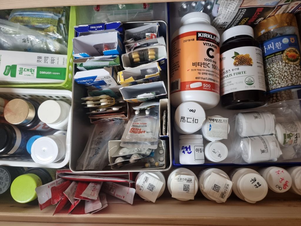 영양제와 약 봉투, 건강기능식품 통이 종류별로 정리되어 있는 서랍 내부 모습